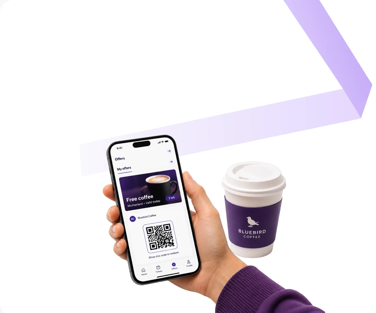 A hand holding a phone showing an Offers screen with a free-coffee voucher and a QR code, beside a printed Bluebird Coffee takeaway cup